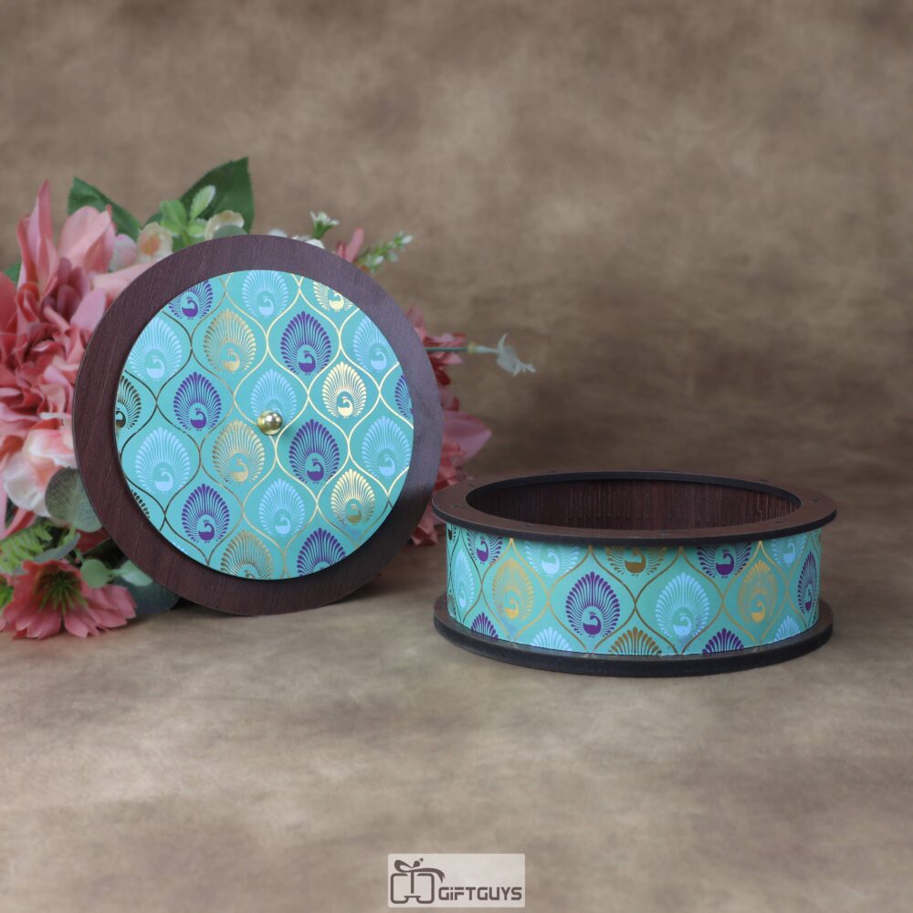 Close up of teal and gold peacock feather Pichwai art on round wooden dry fruit box by Giftguys.in